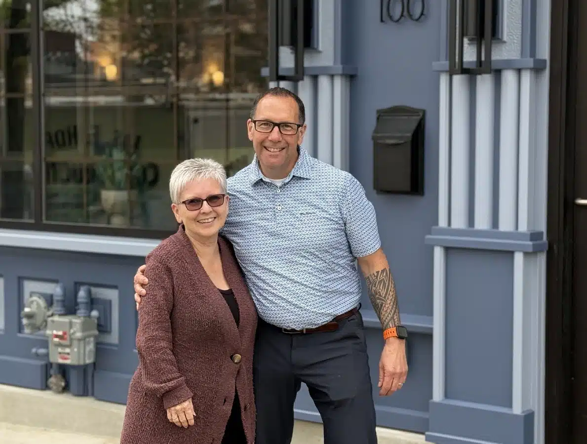 Denise (left) and Rick (right) standing together outside, by the cafe